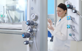 Lab worker with regulators mounted on wall